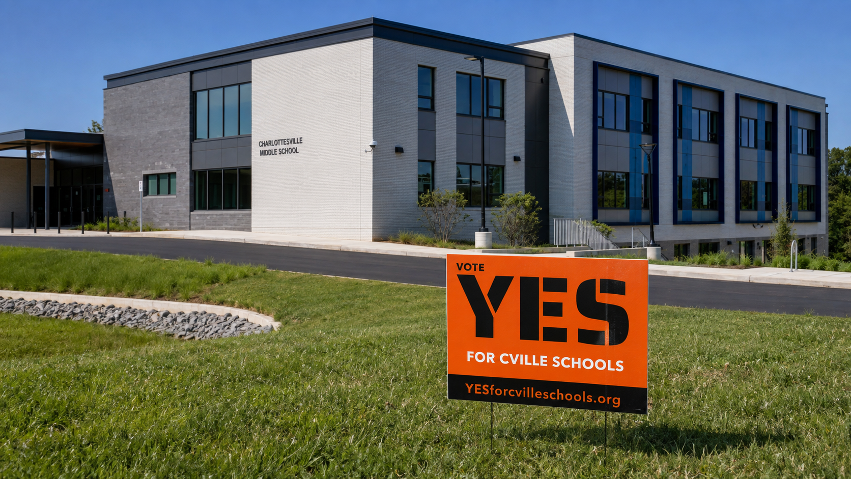 A black and orange Vote YES for Cville Schools yard sign outside Charlottesville Middle School